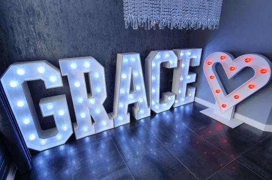 Large letters spelling Grace with a love heart, all illuminated with individual bulbs inset in the letters and heart