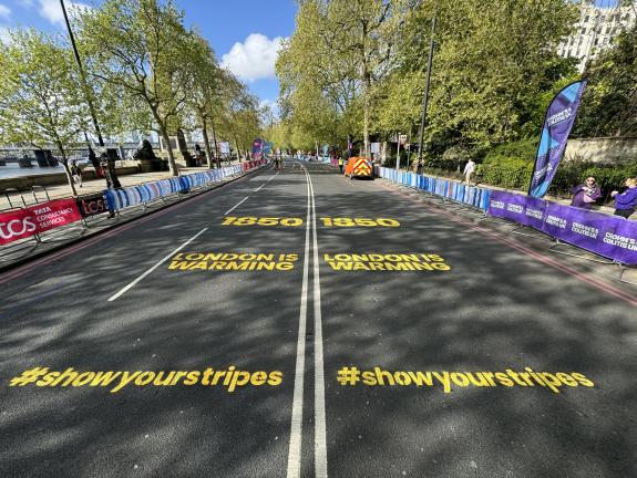 Large yellow logos stencilled on the road for the London Marathon