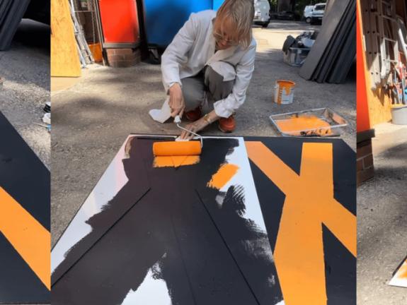 Letters being applied with stencils and a paint roller