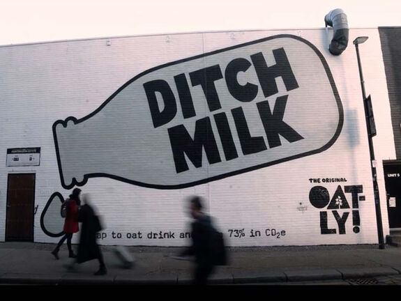 Ditch Milk advert for Oatly sprayed with stencils onto building