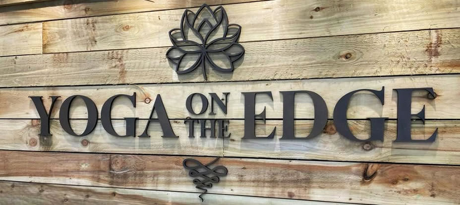 Yoga on the Edge interior sign on pallet wood background