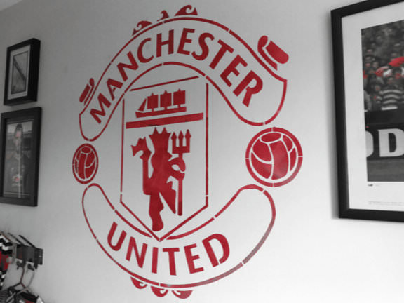 Manchester United logo stencilled on a bedroom wall