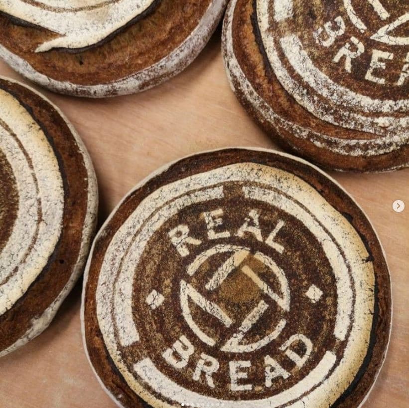 Round loaves of bread with Real Bread logo stencilled on