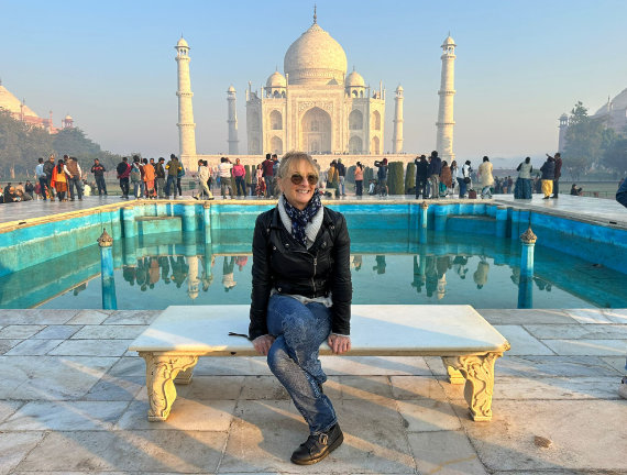 Sarah Gleave sitting on a bench with the Taj Mahal in the background