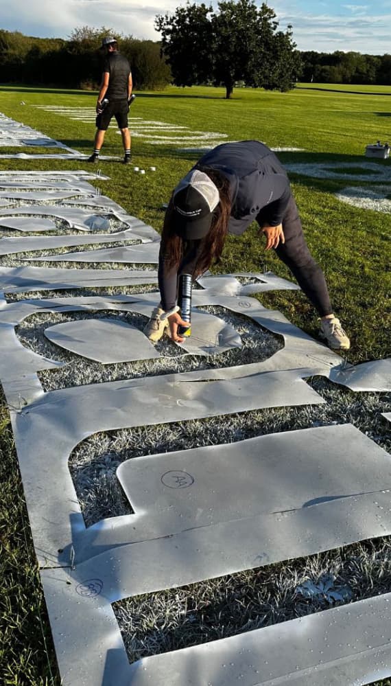 Spray painting the letters for a 45m wide logo